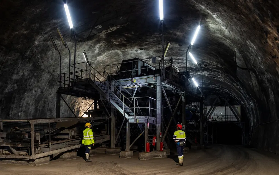 A photo showing a set of metal stairs and platforms inside a dark, dome-ceiled room with walls made of rock.