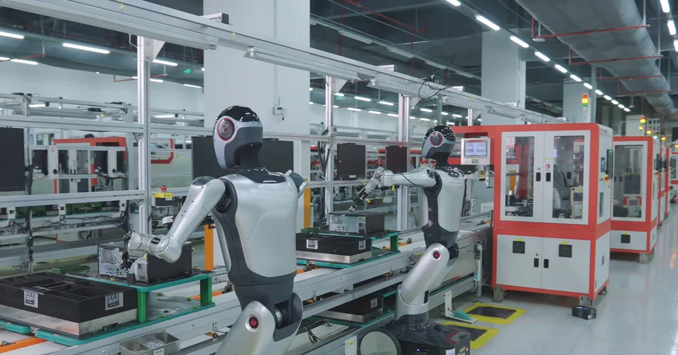 Humanoid robots assembling electronics on an automated factory production line