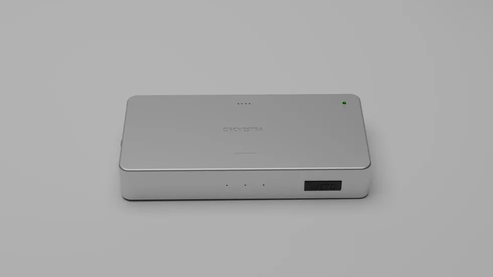 Sleek silver rectangular electronic device labeled \u201cORCHESTRA\u201d on a light gray background.