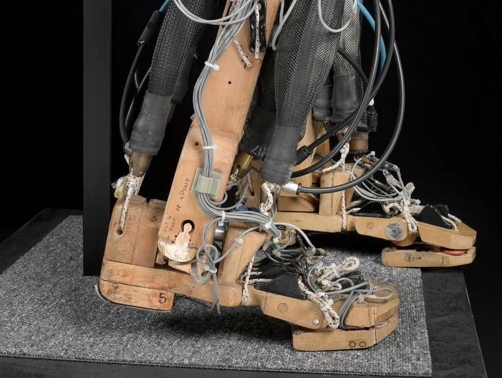Photo of two articulated feet made of pieces of wood strung with wires and other components.