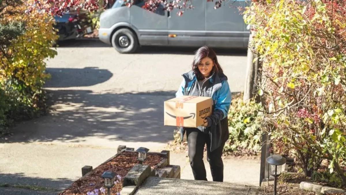 Amazon driver bringing package up the stairs to the home