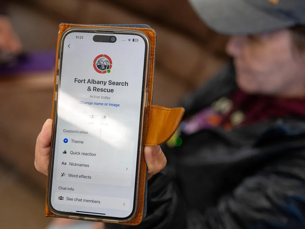 A photo that shows the screen of a cellphone displaying the words \u201cFort Albany Search & Rescue.\u201d  