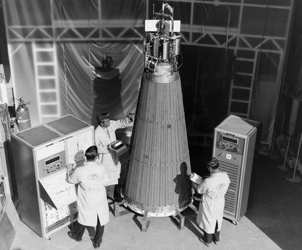 A roughly four-meter-tall conical device is surrounded by ground technicians. 