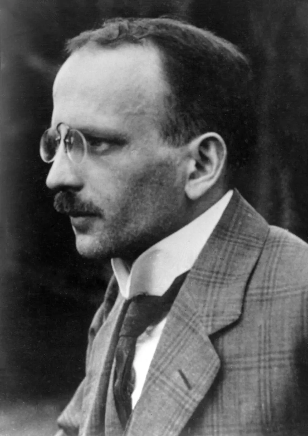 Black and white photo of a balding white man with a mustache and pince nez. 