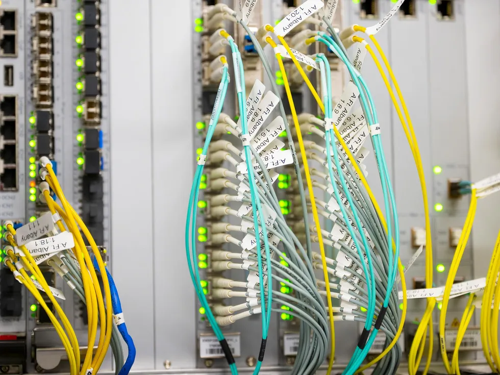 Network server rack with labeled fiber optic cables and glowing status LEDs