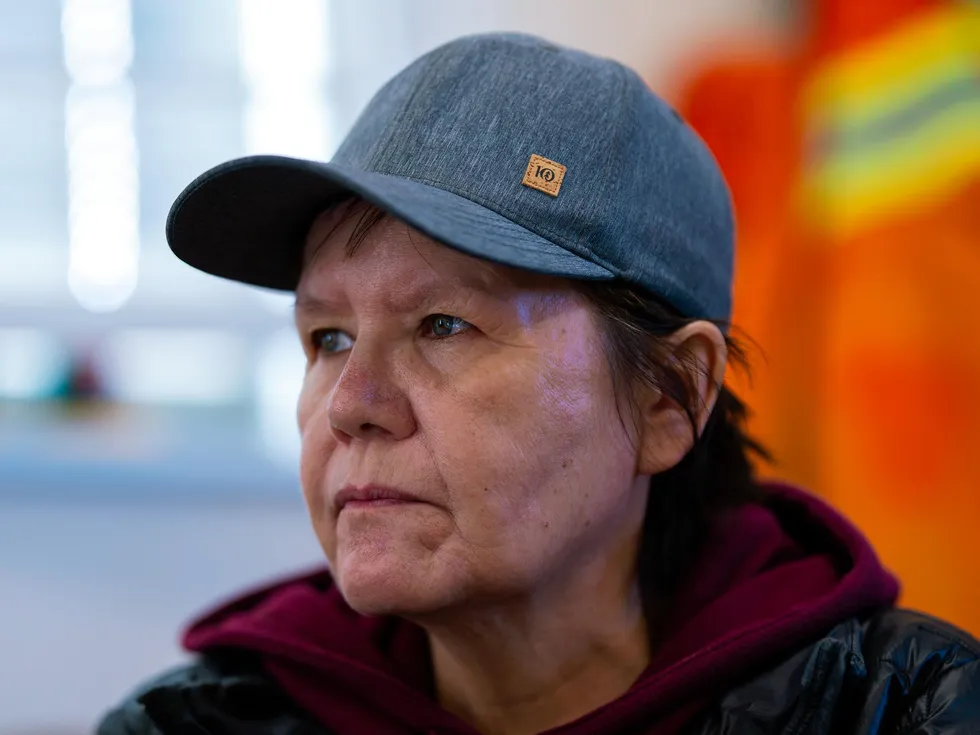 Person in gray cap and maroon hoodie looking thoughtfully to the side