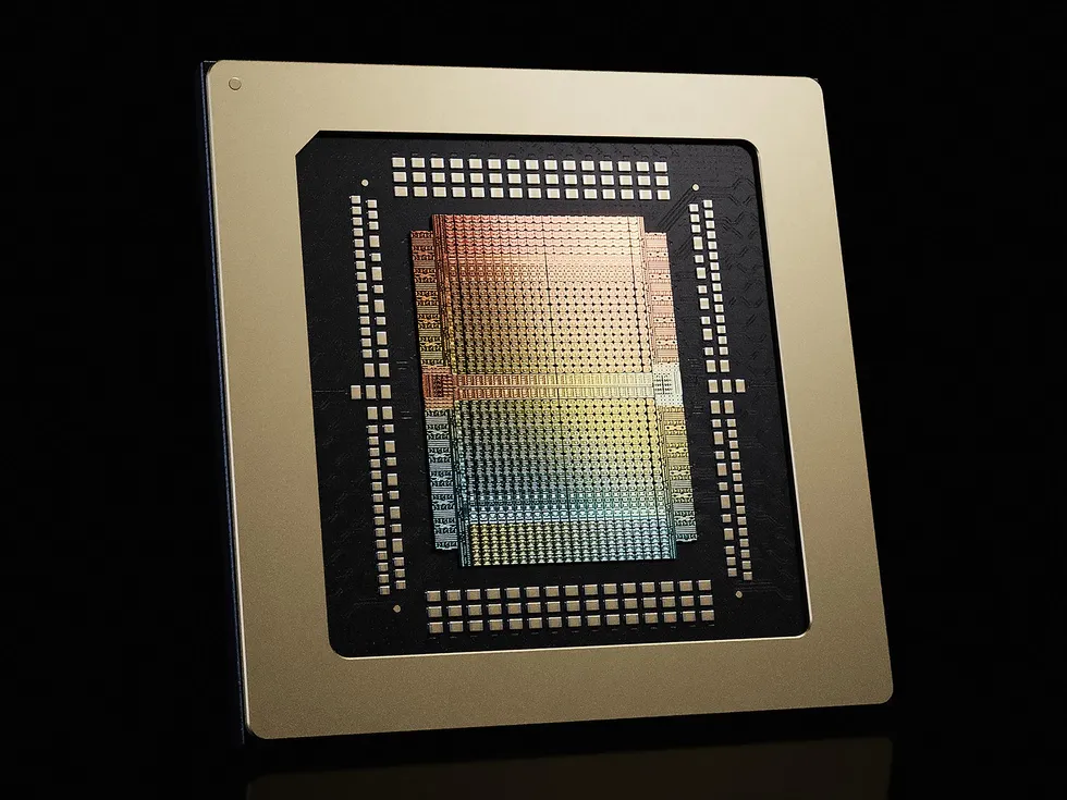 Close-up of a gold computer chip with rainbow-colored circuitry on black background