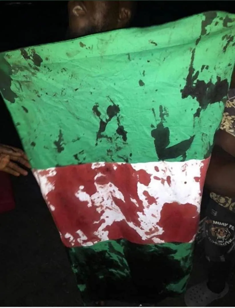 #EndSars: Blood stains on the Nigerian flag. After security operatives opened fire on peaceful protesters at Lekki toll gate, Lagos. [Source: Twitter]