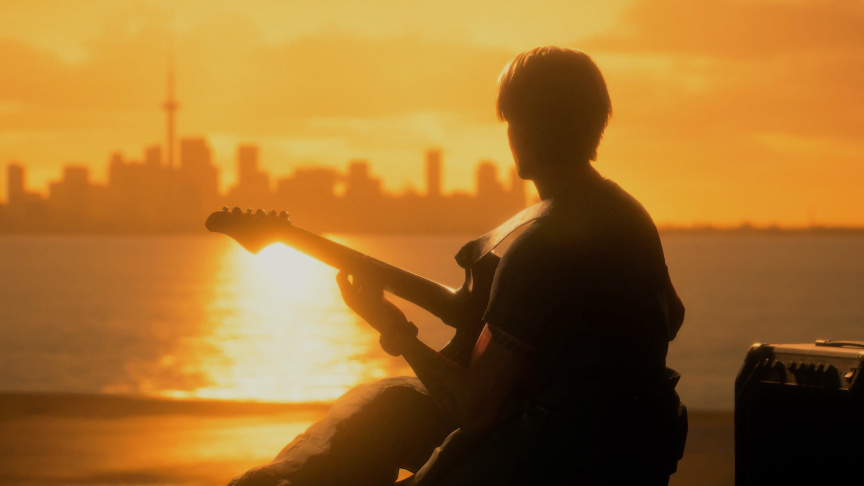 An in-game screenshot of a cutscene wherein a man sits on the deck of a ship at sunsets, playing an electric guitar.