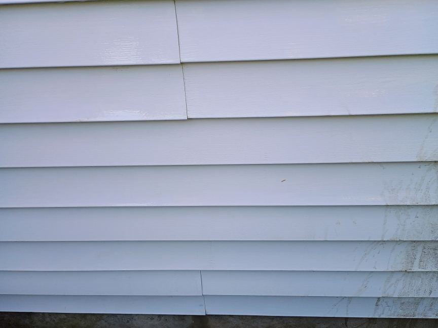 A view of house siding after it was cleaned with a LawnMaster pressure washer. The result looks very clean.