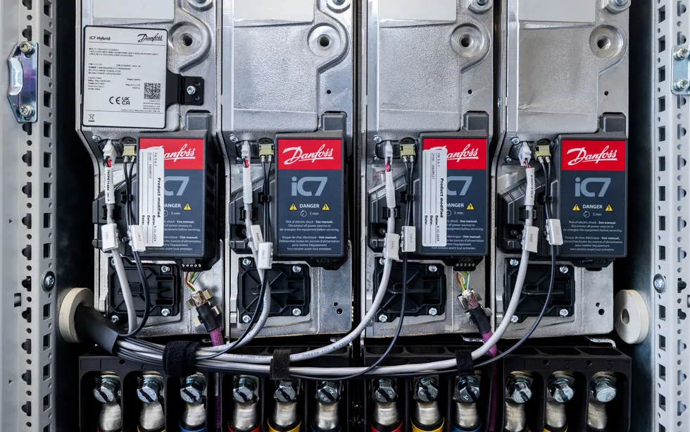 A stack of four rectangular devices with wires protruding, displaying the Danfoss logo 